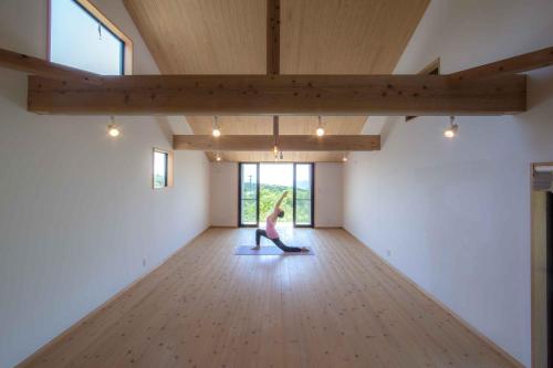 a woman doing a yoga pose in a room at Ananda Chillage Yakushima in Yakushima