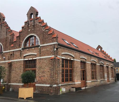 un bâtiment en briques avec des fenêtres et un toit rouge dans l'établissement b room, à Bruges
