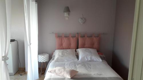 uma cama com uma cabeceira laranja num quarto em Bordl'o em Aurec-sur-Loire