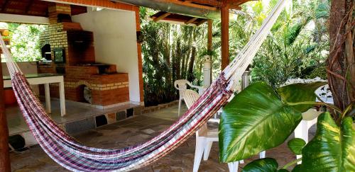 een hangmat op een veranda van een huis met planten bij Pousada na Montanha in Domingos Martins