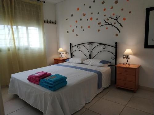 a bedroom with a bed with two bags on it at Apartamentos Tamarindo Cala de Finestrat in Cala de Finestrat
