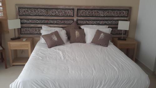 1 dormitorio con 1 cama blanca grande con almohadas en Element Bay Lux Beach Apartment, en Cap Malheureux