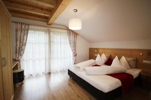 a bedroom with a large bed with white and red pillows at Residenz Erschbaum in Valdaora