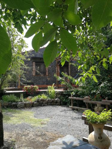 a garden with a bench and a building at Casa etna in Bronte