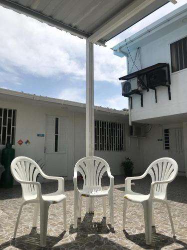 three white chairs sitting on a patio in front of a building at Tropical Dreams in San Andrés
