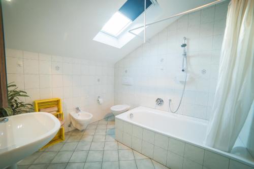 a bathroom with a tub and a toilet and a sink at Lochererhof in Appiano sulla Strada del Vino