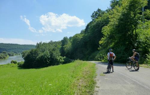 two people riding bikes on a road next to a river at Na końcu świata in Dubiecko