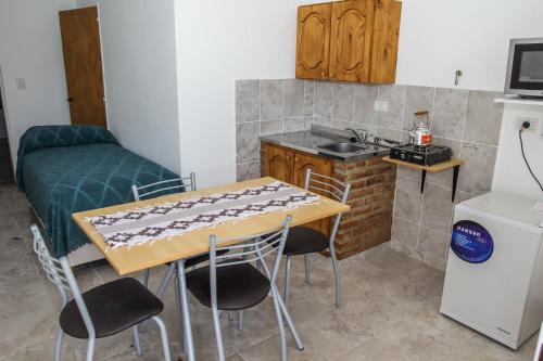 - une cuisine avec une table et des chaises dans la chambre dans l'établissement Departamentos El Alamo, à Comandante Luis Piedrabuena