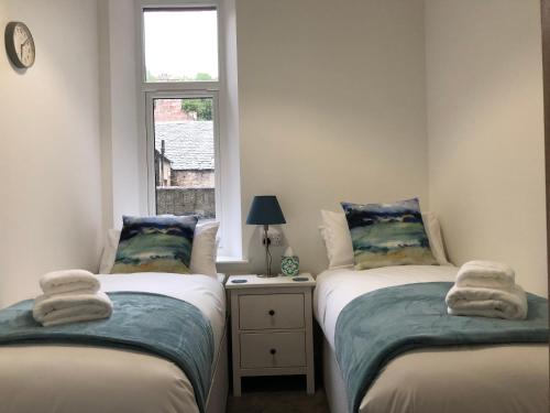 2 aparte bedden in een kleine kamer met een raam bij Dryburgh Apartment No3 in Inverness