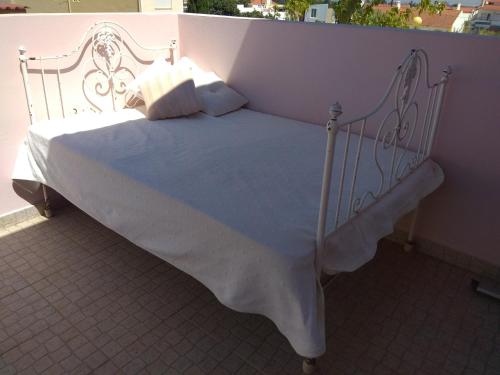 a white bed with pillows on a balcony at Quarto privado Alentejo Litoral in Grândola