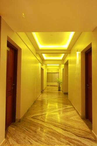 an empty corridor in an office building with yellow ceilings at Orionis Kannur in Kannur