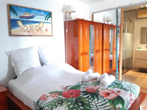 a bedroom with a bed with towels on it at Domaine Choco Vanille in Deshaies