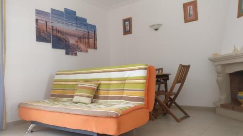 uma cadeira laranja sentada numa sala de estar ao lado de uma lareira em Manta Rota Beach Haven na Manta Rota