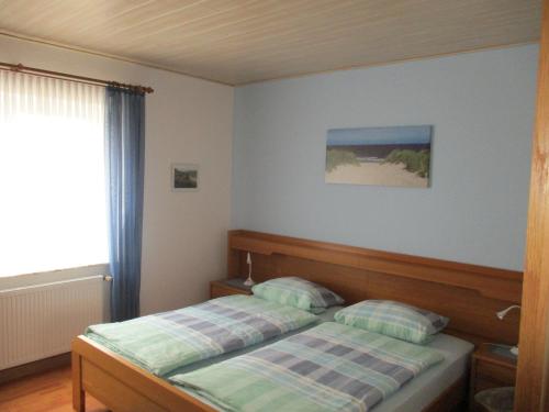 - une chambre avec un lit et une fenêtre dans l'établissement FeWo Trientje, à Uplengen