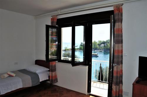 a bedroom with a window with a view of a river at Apartmani Kadmen in Ika