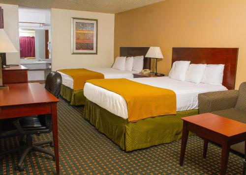 GuymonにあるBudget Inn & Suites Guymonのベッド2台とデスクが備わるホテルルームです。