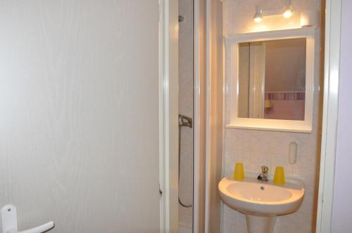 Baño blanco con lavabo y espejo en Penzion Zuzana, en Staré Splavy