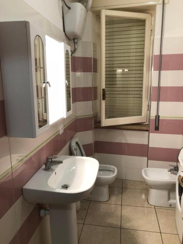 La salle de bains est pourvue de 2 toilettes, d'un lavabo et d'un miroir. dans l'établissement Terni In Centro, à Terni