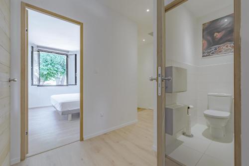 La salle de bains est pourvue d'un miroir, de toilettes et d'un lit. dans l'établissement La maison du Boulodrome, à La Bruguière