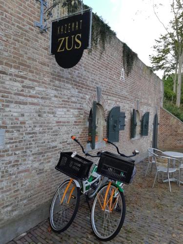 two bikes parked next to a brick building at Kazemat Zus in Woudrichem