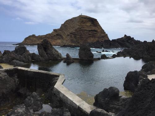 a rock island in the middle of the ocean at Casa da Grota in Porto Moniz