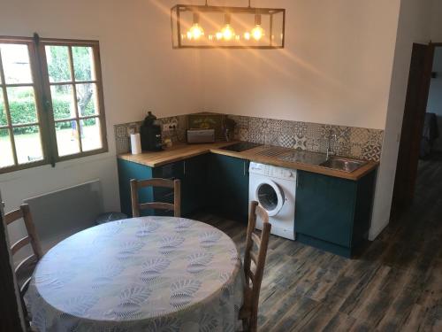 - une cuisine avec une table, un évier et un lave-linge dans l'établissement Petite Campagne au coeur des gorges du Verdon, à Allemagne-en-Provence