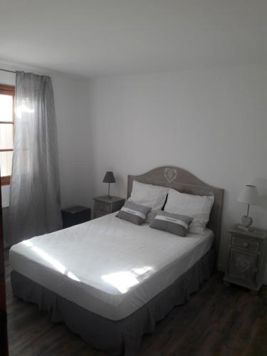 une chambre avec un grand lit blanc avec des oreillers dans l'établissement Petite Campagne au coeur des gorges du Verdon, à Allemagne-en-Provence