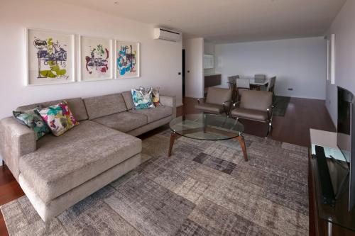 a living room with a couch and a glass table at Spacious luxury holiday apartment with a great view, Funchal, free wifi and parking in Funchal