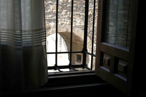a window with a bird looking out of it at La Casa del Seise in Baeza
