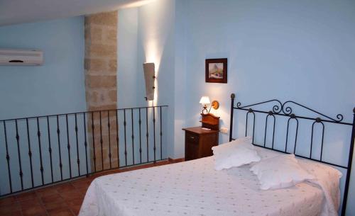 a bedroom with a bed with white sheets and pillows at La Casa del Seise in Baeza