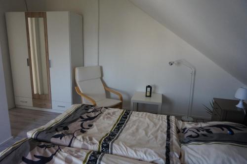 1 dormitorio con 1 cama y 1 silla en Ferienwohnung am See, en Bad Lippspringe