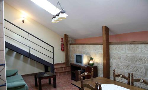 a living room with a staircase and a tv at La Casa del Seise in Baeza