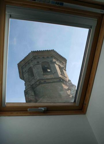 a reflection of a tower in a glass window at La Casa del Seise in Baeza