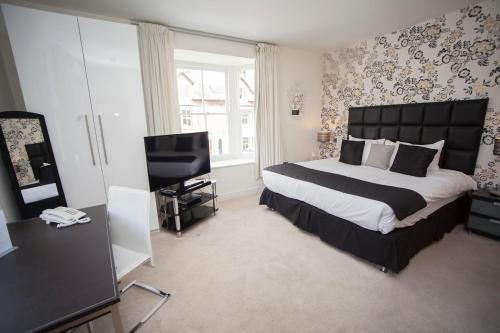 a bedroom with a large bed and a television at Ethos Hotel in Oxford
