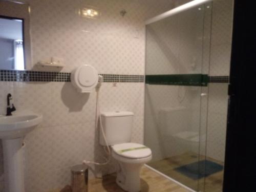 a bathroom with a toilet and a shower and a sink at Hotel Cajuína City in Teresina