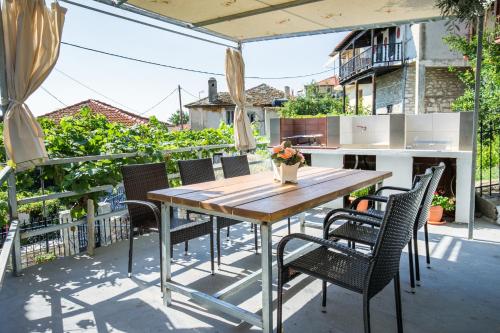 an outdoor patio with a wooden table and chairs at Sotiria's House in Kallirákhi