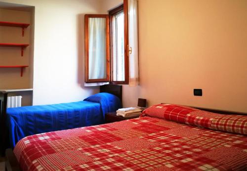 2 camas en una habitación con sábanas azules y rojas en Agriturismo FranciaCorta, en Passirano