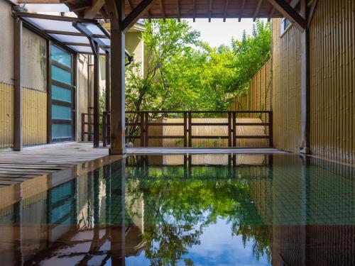 - une piscine dans une maison avec une clôture et des arbres dans l'établissement Awara Onsen Minoya Taiheikaku, à Awara