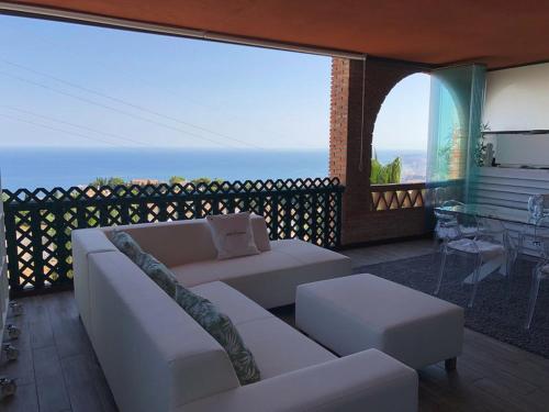 ベナルマデナにあるLuxury Sea View - Reserva del Higuerónのリビングルーム(ソファ付)が備わり、海の景色を望めます。