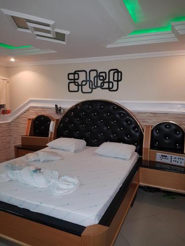 a bedroom with a large bed with a black headboard at Motel Morumbi (Adults Only) in Taboão da Serra
