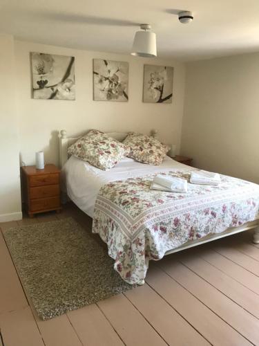 a bedroom with a bed and a nightstand and pictures on the wall at Red Lion Inn in Sidbury