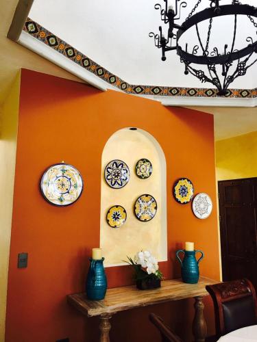 a room with plates on a wall with a shelf at Villa El Retiro Luxury Property in Alajuela City