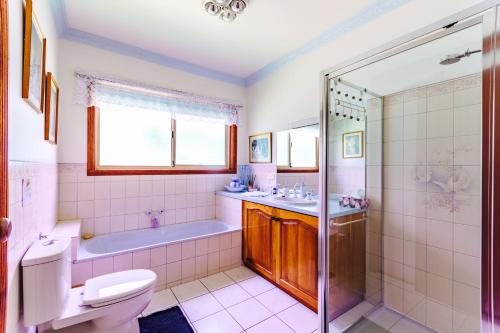 y baño con bañera, aseo y ducha. en Fairy Wren Cottage Country to Coast Retreat en Wallington