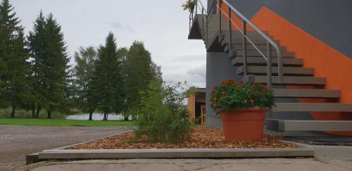 a building with a staircase and a pot of flowers at Ilmatsalu Motell in Ilmatsalu