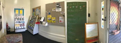 a classroom with a green board in a room at Wander Inn Bunbury in Bunbury