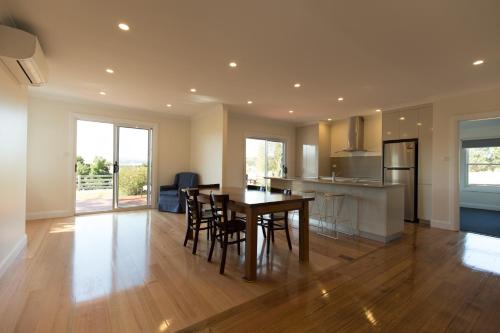 a kitchen and dining room with a table and chairs at Leichhardt Cottages in Relbia
