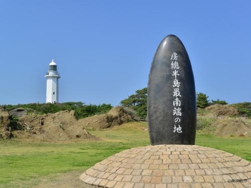 a rock monument with a lighthouse in the background at Nangoku Hotel in Minamiboso