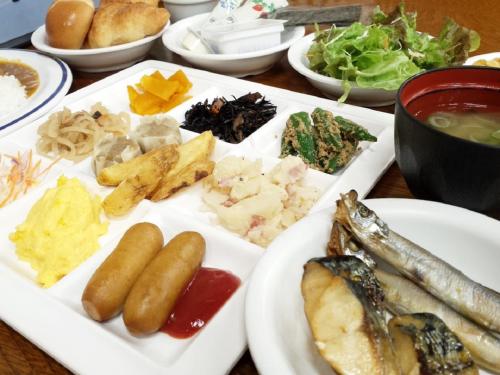 a table with a plate of food with fish and other foods at Nangoku Hotel in Minamiboso