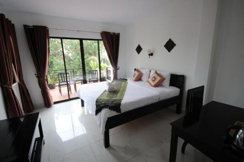 a bedroom with a bed and a large window at Green Life Cottage in Siem Reap