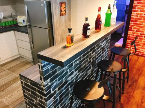 a bar with two stools and bottles of alcohol at Perfect Getaway @Vivacity in Kuching